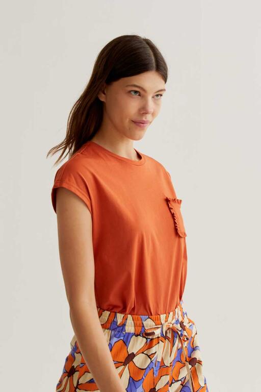 Camiseta Sunset naranja con bolsillo frontal con volante. Combina con el pantalón Sunset Bloom para un look coordinado. nueva coleccion