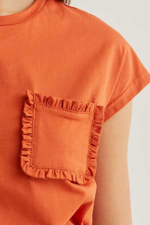 Camiseta Sunset naranja con bolsillo frontal con volante. Combina con el pantalón Sunset Bloom para un look coordinado.