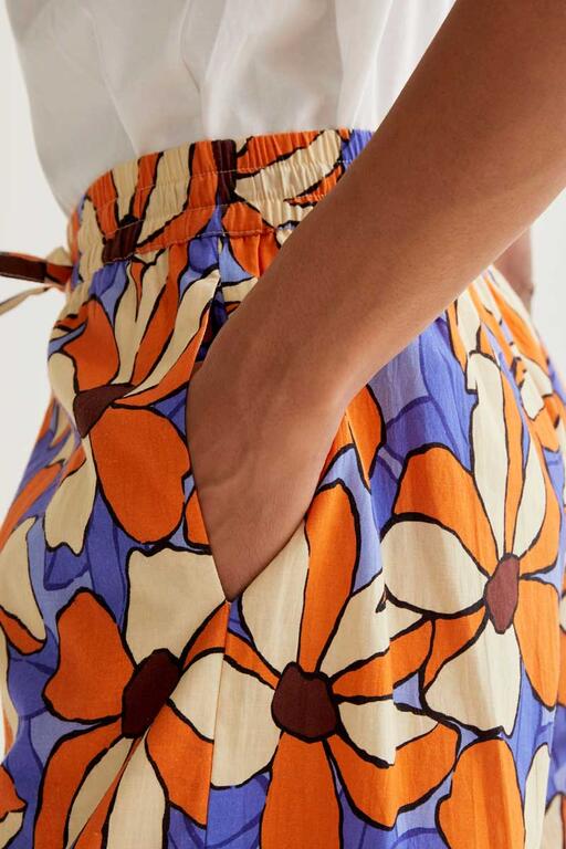 Detalle bolsillos laterales y goma en cinturilla Pantalón Sunset Bloom con estampado floral naranja y azul, cintura elástica y pernera recta amplia. Diseño vibrante de Compañía Fantástica.
