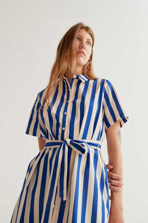 Vista superior de vestido camisero corto de rayas verticales azul y blanco con botones frontales de Compañía Fantástica en Cotton Grey