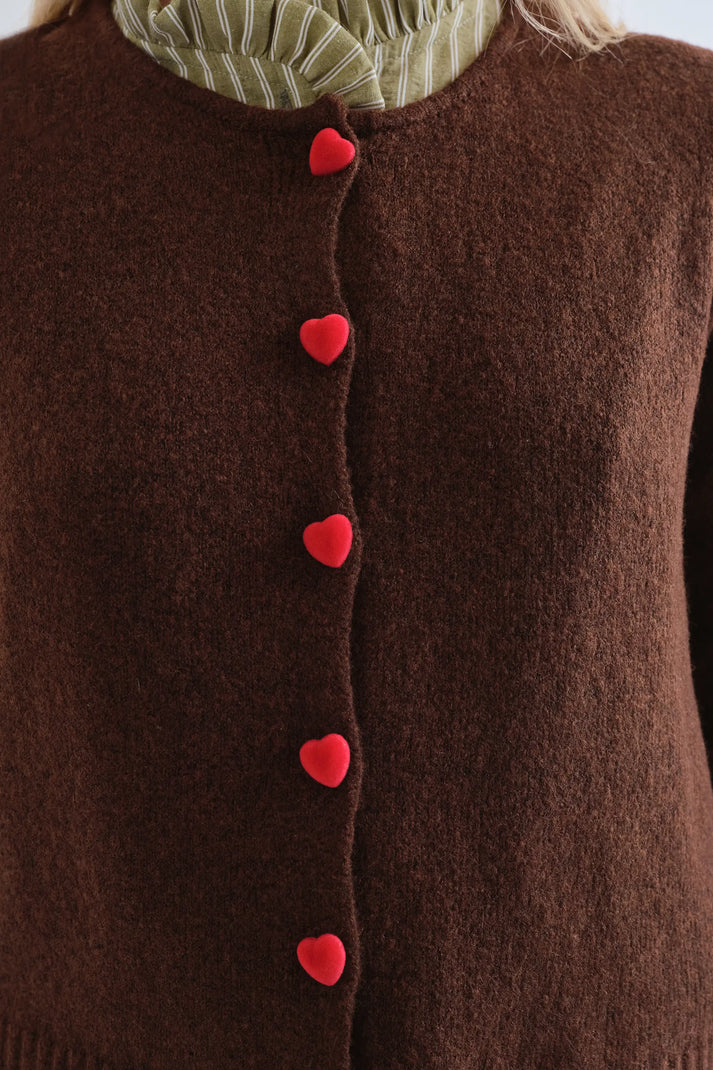 Detalle de los botones rojos en forma de corazón del cárdigan marrón