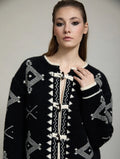 Detalle de la chaqueta de punto Zenda de SKATIE con estampado jacquard geométrico negro y crudo, ribete en contraste y cierres tipo alamar.
