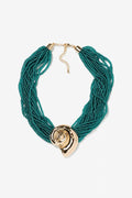 Collar Caracola Turquesa de Vilanova con múltiples hileras de cuentas en color turquesa y adorno central dorado.