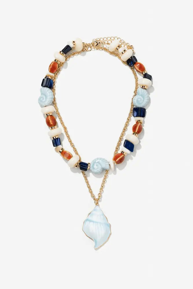 Collar Náutica de Vilanova de doble vuelta con concha azul, cuentas decorativas y detalles dorados.