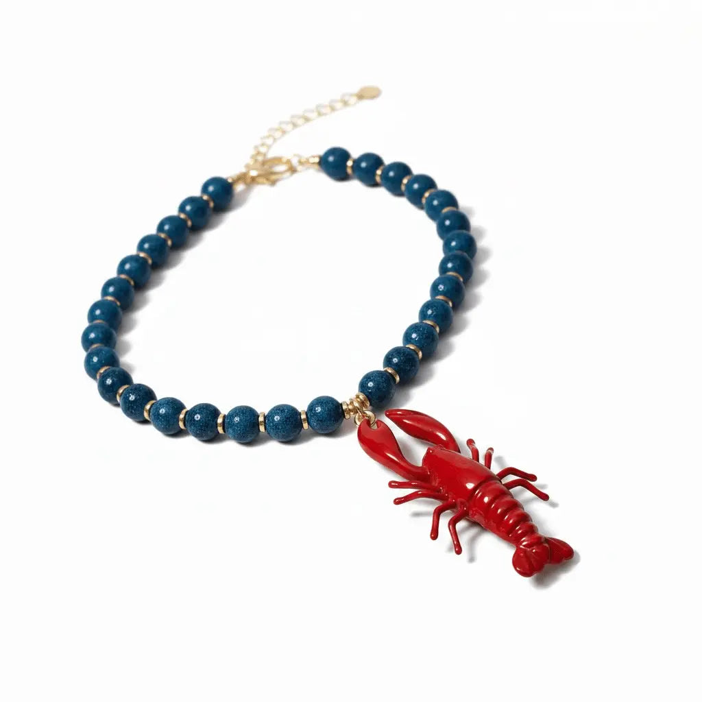 Collar de verano con colgante de langosta roja, abalorios azul celeste y conchas naturales de Cotton Grey.