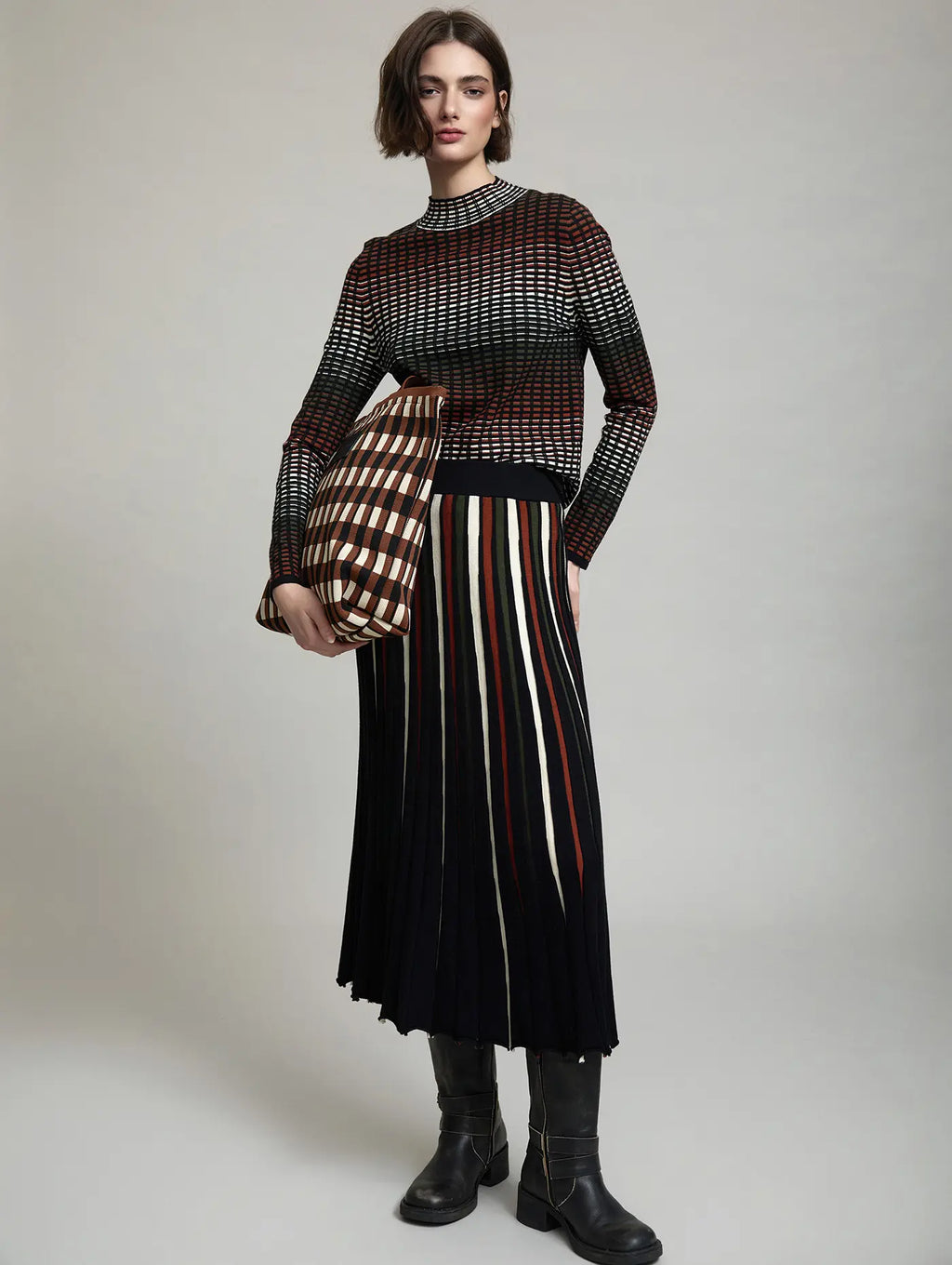Look de mujer con Falda Midi Margot Negra de punto, diseño de líneas verticales irregulares multicolor con efecto degradado, combinada con jersey estampado
