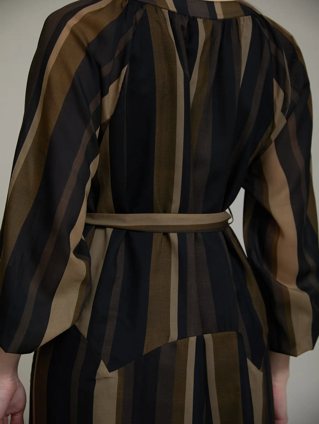 Detalle de la cintura del Vestido Marnie de SKATIE con cinturón del mismo tejido, hebilla rectangular y estampado de rayas verticales en tonos tierra