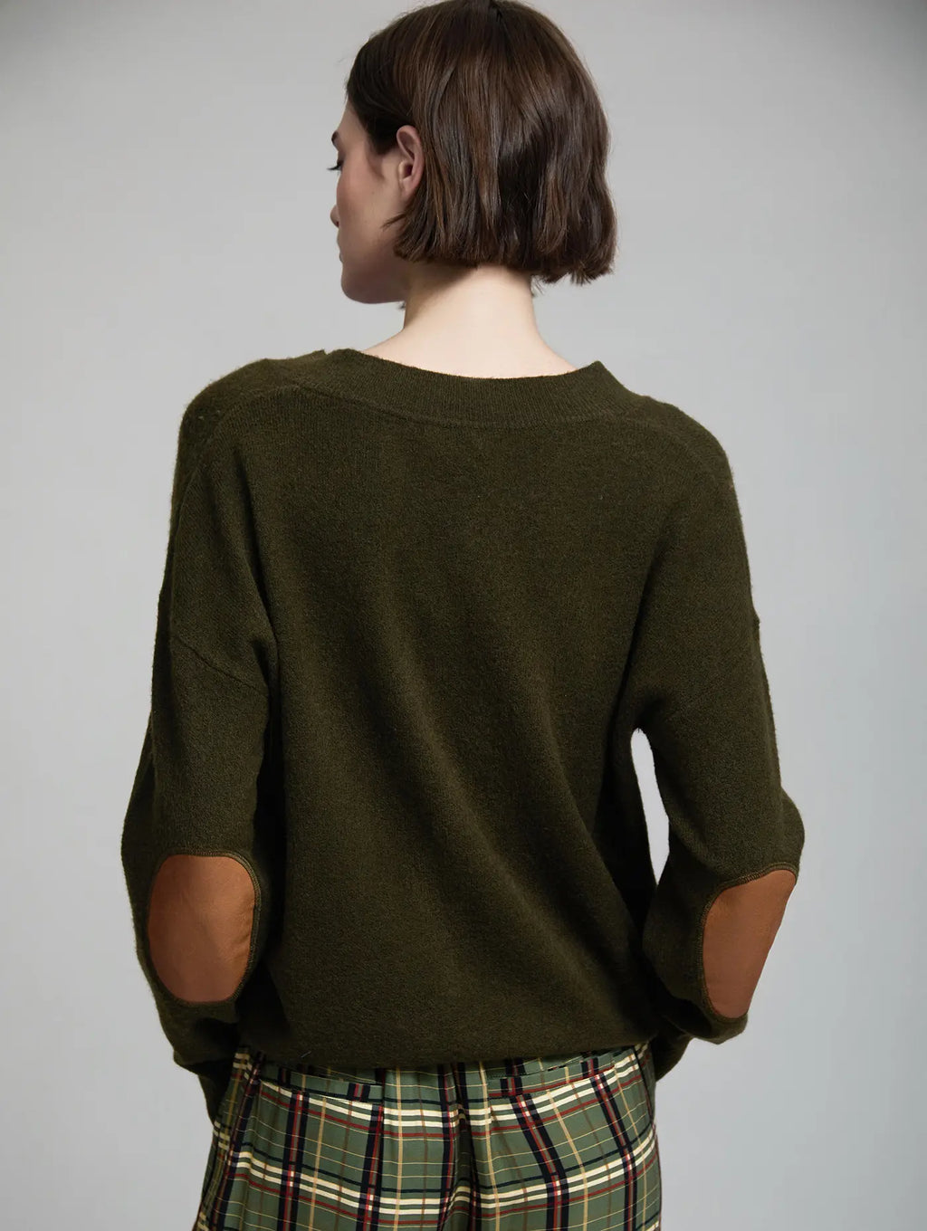 Jersey Cambridge verde oliva de punto para mujer visto de espalda, con corte relajado y coderas ovaladas en contraste color camel
