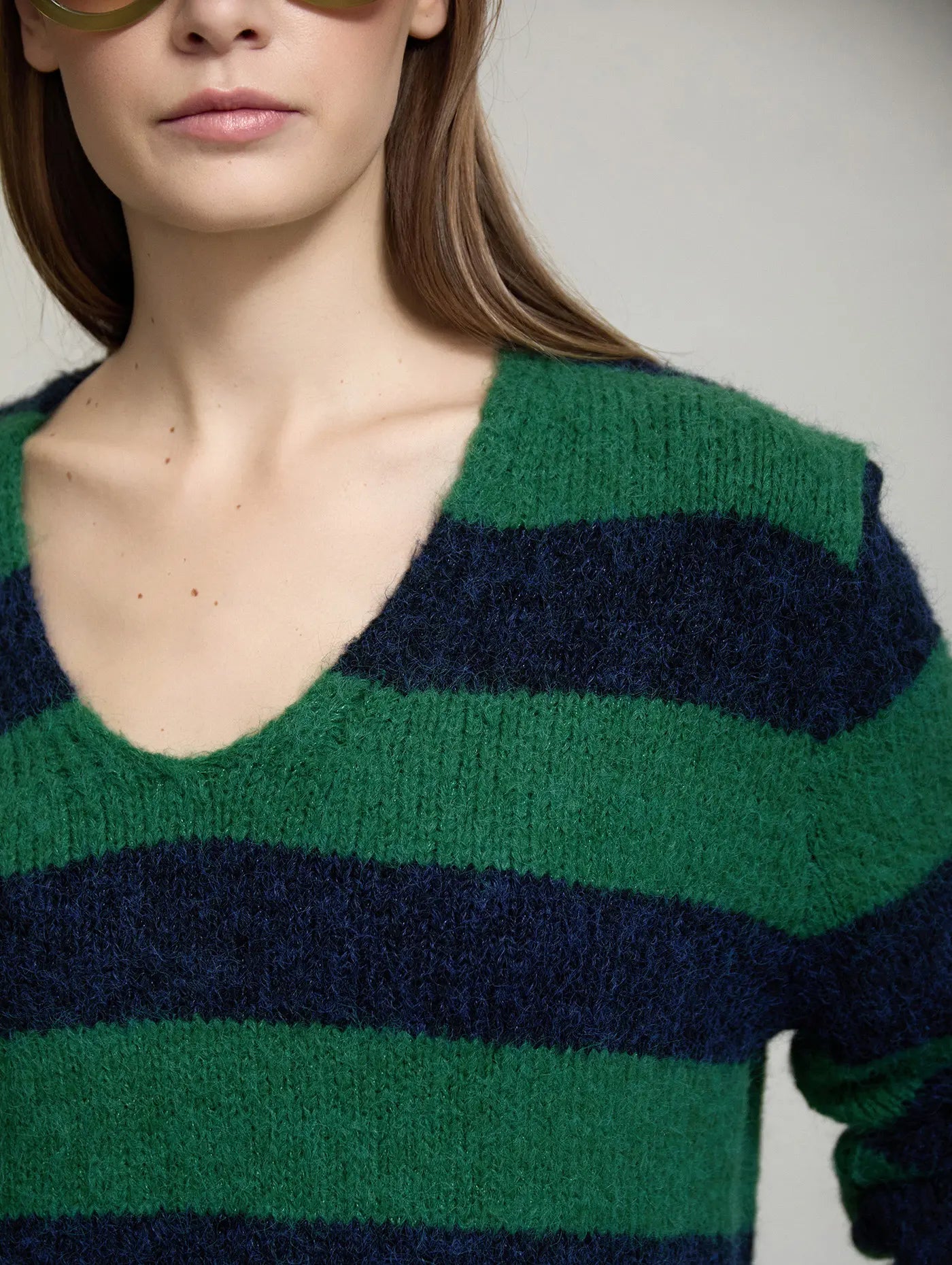 Detalle del escote en V del Jersey Vermont de SKATIE de punto suave a rayas verdes y azul marino, con textura ligeramente esponjosa