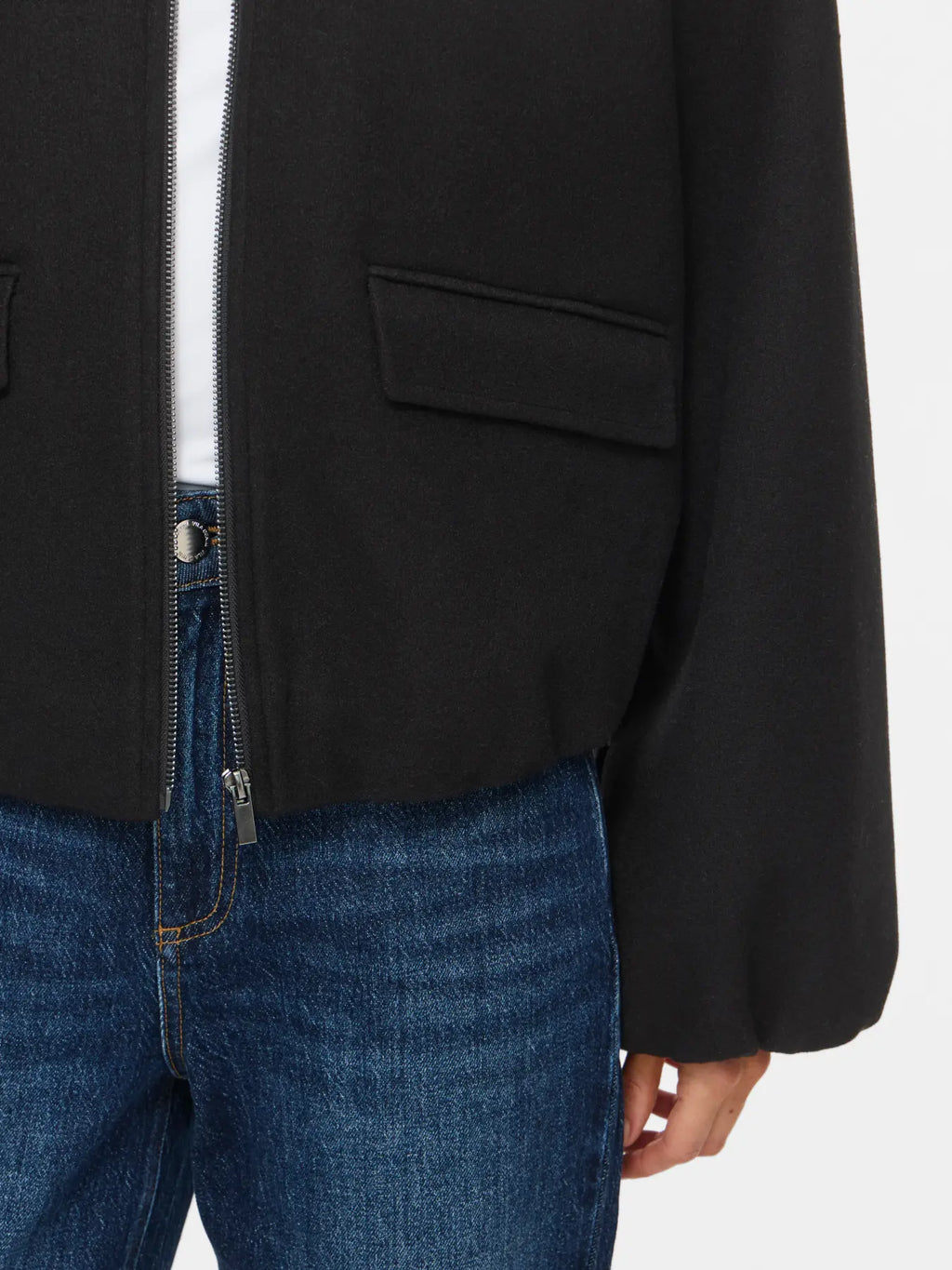 Detalle del bolsillo con tapeta de la chaqueta Adele y puño con volumen
