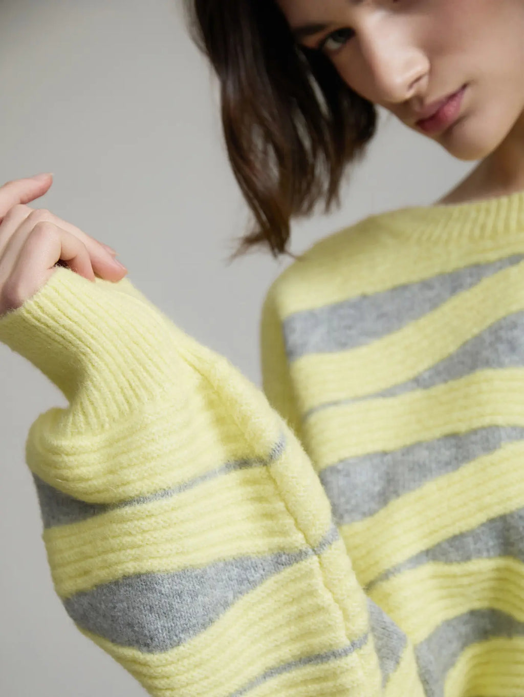 Detalle de la manga larga del Jersey Blondie de SKATIE con punto intarsia de ondas en amarillo y gris y puño de canalé