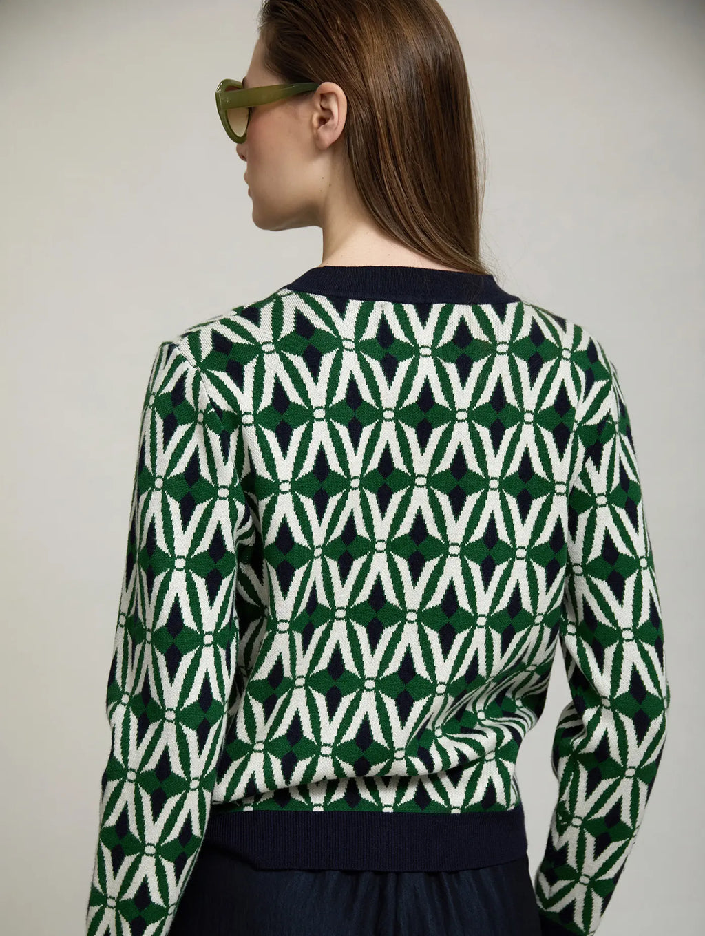Cárdigan Jacquard Odette de SKATIE visto por detrás con estampado geométrico en verde, crudo y azul marino, cuello y bajo de punto azul marino