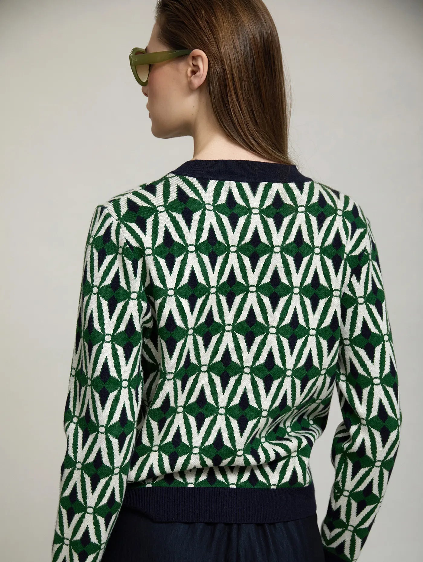 Cárdigan Jacquard Odette de SKATIE visto por detrás con estampado geométrico en verde, crudo y azul marino, cuello y bajo de punto azul marino