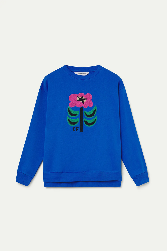 Detalle del parche floral multicolor Neo Garden sobre sudadera azul cobalto de algodón