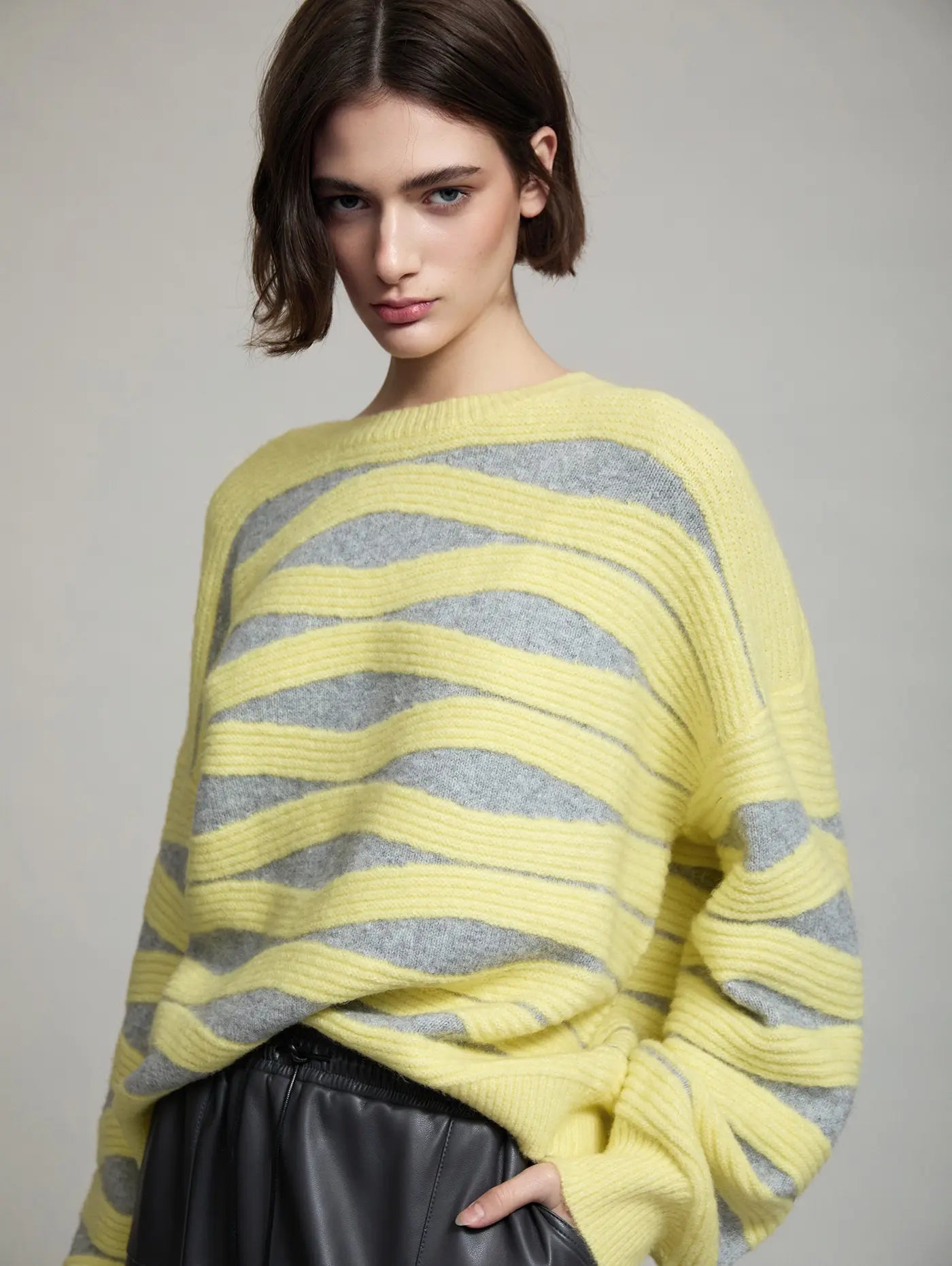Vista frontal del Jersey Blondie de SKATIE de punto intarsia con diseño de ondas en amarillo y gris, cuello redondo, manga larga y corte amplio
