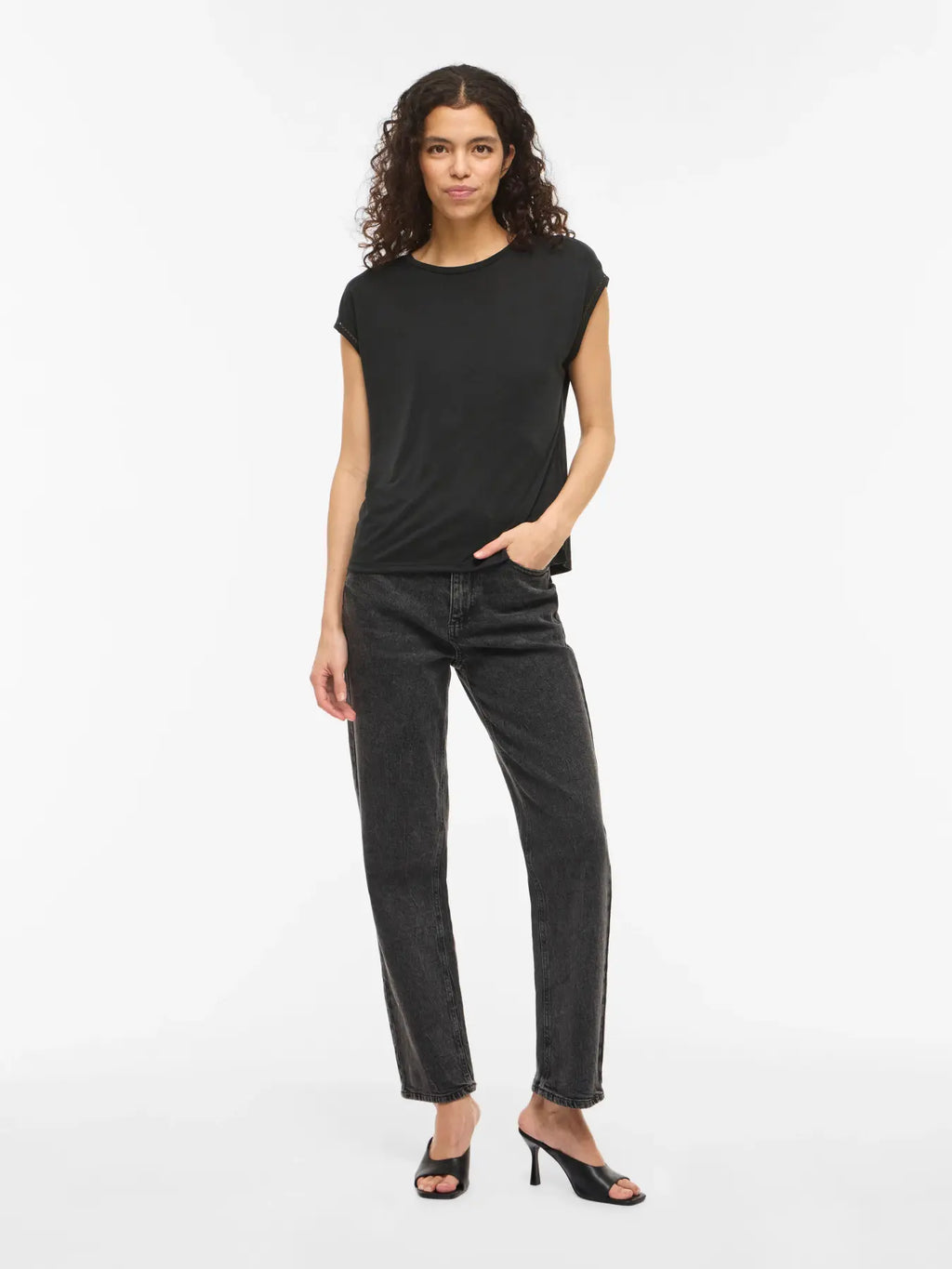 Camiseta negra Vila de manga caída y cuello redondo en tejido fluido, con detalle calado en el borde de la manga que aporta un acabado delicado y femenino. Ajuste recto y caída ligera.