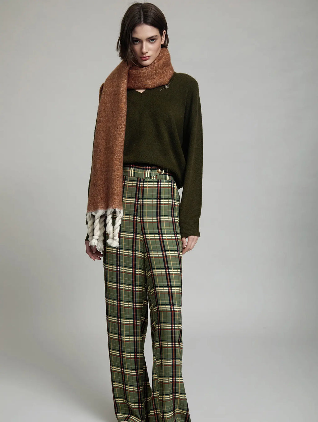 Pantalón de cuadros Kensington de SKATIE con estampado tartán verde oliva y pernera ancha combinado con jersey verde y bufanda
