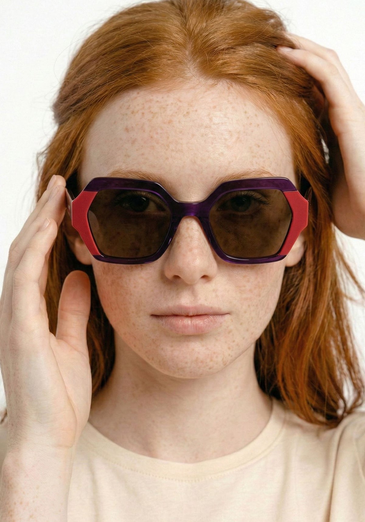 modelo con gafa de sol geométrica en morado y rojo  marca noco en cotton grey