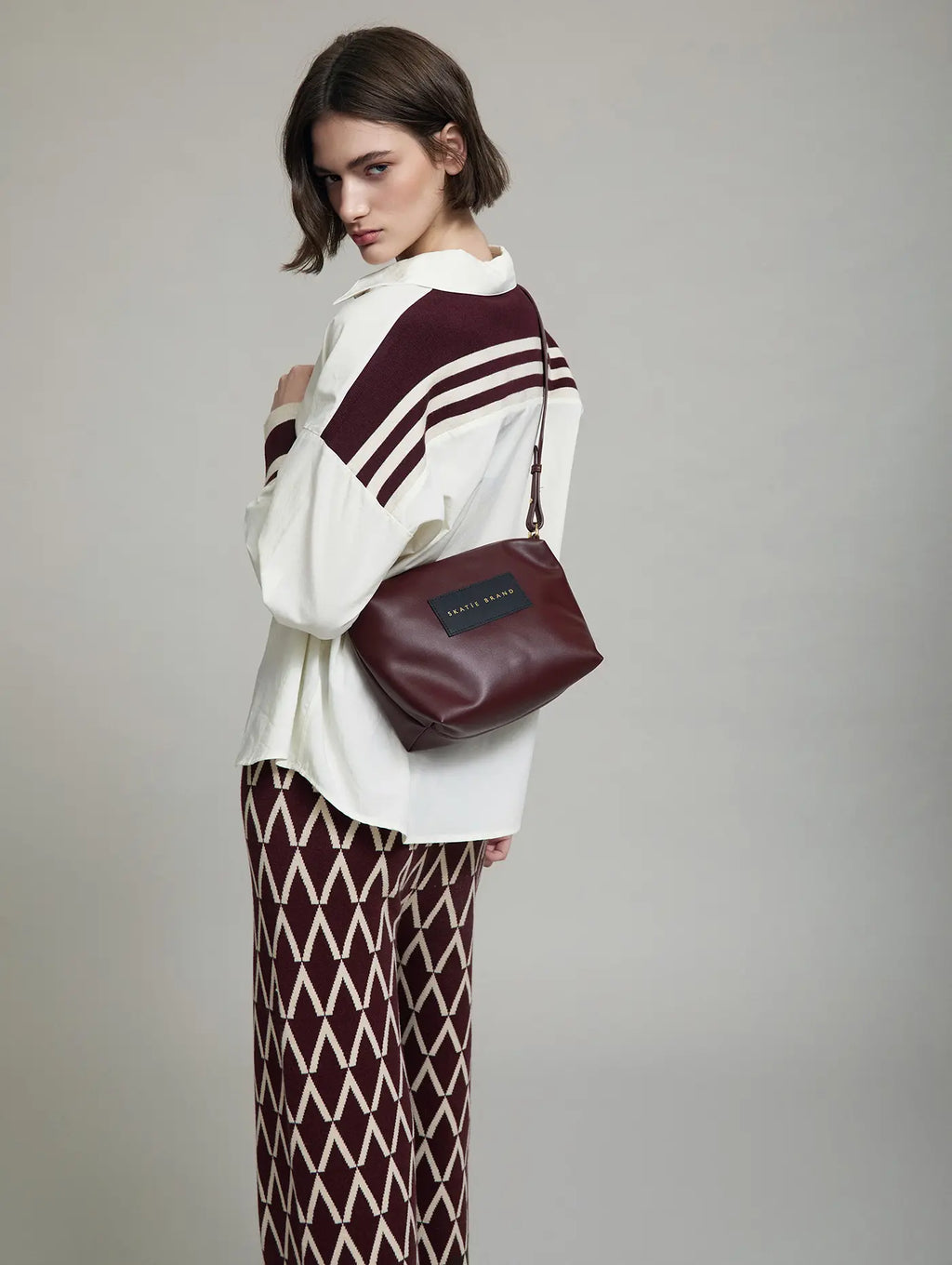 Modelo con Bolso tote granate efecto cesta con bandolera y neceser interior como bolso independiente con bandolera skatie brand en cotton grey