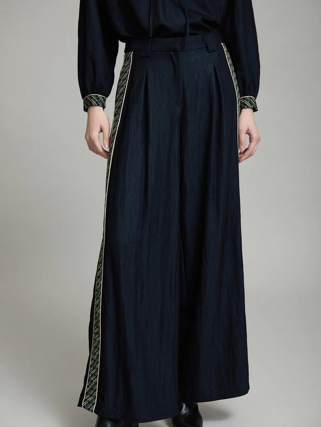 Vista frontal del Pantalón Margot de SKATIE azul marino, de tiro alto y pernera extra ancha, con pinzas delanteras, bolsillos y bandas laterales estampadas