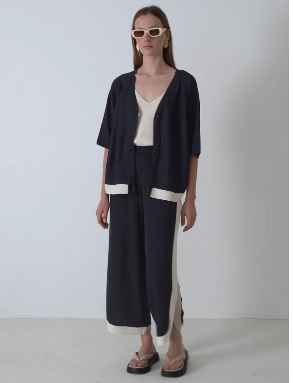 Video en movimiento de modelo con el conjunto de lurex llamado rivera fluido de punto azul marino y raya beige Skatie