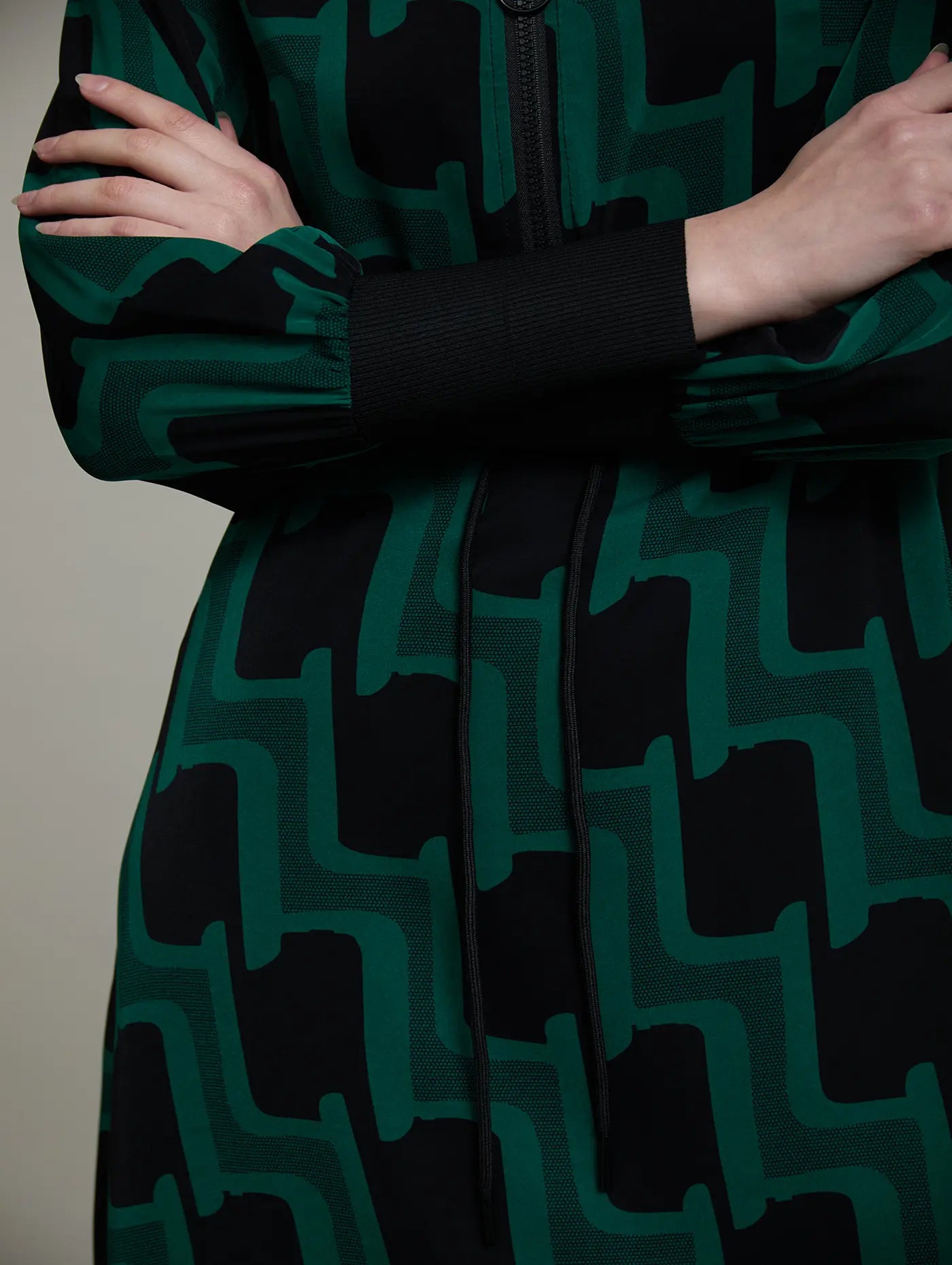 Detalle del estampado geométrico verde botella y negro del vestido Sylvie de SKATIE con manga larga abullonada y puño de punto negro