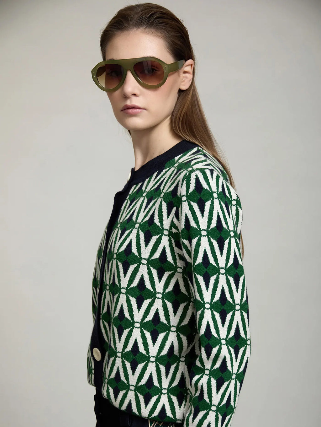 Cárdigan Jacquard Odette de SKATIE visto de perfil con diseño geométrico verde, crudo y azul marino, cuello redondo y cierre frontal de botones
