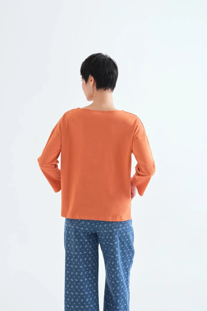 Camiseta naranja de algodón con flor delantera y hombros caídos