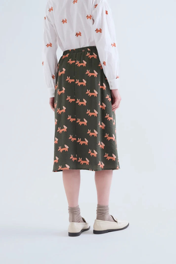 Falda midi verde con estampado de zorros combinada en look de mujer