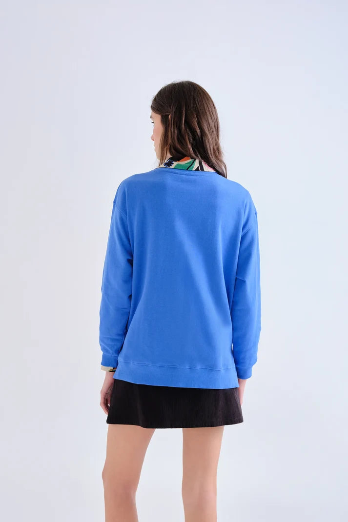 Sudadera azul cobalto con parche de flores Neo Garden combinada en look de mujer