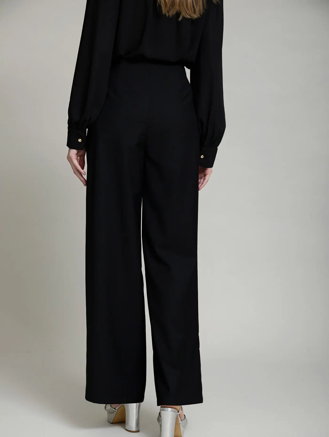 Vista trasera del Pantalón Celine de SKATIE en color negro, de tiro alto y pernera ancha, con espalda lisa y silueta recta de caída fluida